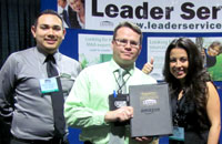 Michael Krause posing with Leader employees and Kindle Fire