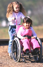 Girl pushing child on wheelchair